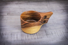 Laden des Bilds im Galerie-Viewer, A single handcrafted acacia Kuksa mug in Scandinavian design with ergonomic double handle, decoratively placed on a grey wooden table