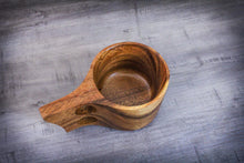 Laden des Bilds im Galerie-Viewer, A single handcrafted acacia Kuksa mug in Scandinavian design with ergonomic double handle, decoratively placed on a grey wooden table