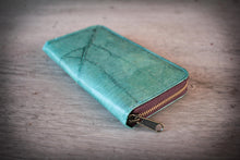 Laden des Bilds im Galerie-Viewer, Vegane Geldbörse in Türkis mit Reißverschluss, aus recycelten Blättern, auf rustikalem Holzuntergrund. Die feine Blattstruktur ist sichtbar.

Vegan turquoise zippered wallet made from recycled leaves, showing the subtle leaf structure, resting on a rustic wooden surface.
