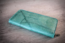 Laden des Bilds im Galerie-Viewer, Vegan turquoise zippered wallet made from recycled leaves, showing the subtle leaf structure, resting on a rustic wooden surface.

Vegane Geldbörse in Türkis mit Reißverschluss, aus recycelten Blättern, auf rustikalem Holzuntergrund. Die feine Blattstruktur ist sichtbar.

