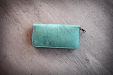 Laden des Bilds im Galerie-Viewer, Türkises Portemonnaie aus recycelten Blättern mit sichtbarer Blattstruktur, vegane Brieftasche mit Reißverschluss von oben fotografiert.

Turquoise wallet made from recycled leaves with visible leaf vein texture, vegan zip-around purse photographed from above.
