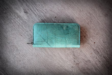 Laden des Bilds im Galerie-Viewer, Turquoise wallet made from recycled leaves with visible leaf vein texture, vegan zip-around purse photographed from above.
Türkises Portemonnaie aus recycelten Blättern mit sichtbarer Blattstruktur, vegane Brieftasche mit Reißverschluss von oben fotografiert.

