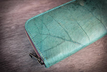 Laden des Bilds im Galerie-Viewer, Detailaufnahme eines türkisen Portemonnaies aus recycelten Blättern mit sichtbarer Blattstruktur und Reißverschluss.

Close-up of a turquoise wallet made from recycled leaves showing the leaf texture and zipper.

