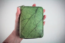 Laden des Bilds im Galerie-Viewer, Nachhaltiges, veganes Portemonnaie aus grünem Blattmaterial mit Reißverschluss, im Close-up in einer Hand vor weißem Hintergrund – umweltfreundliche Geldbörse für Damen und Herren.

Sustainable vegan wallet made from green leaf material with zipper, shown close-up in a hand against a white background – eco-friendly unisex purse.
